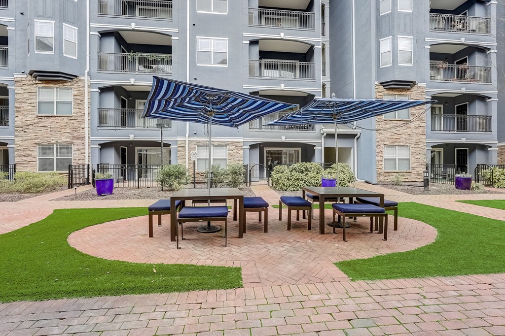 A patio with a table and chairs is in front of a building.