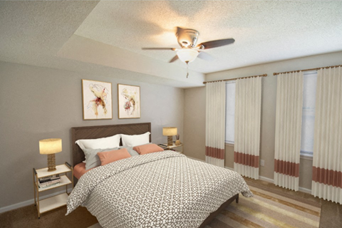 A bedroom with a large bed and a ceiling fan.