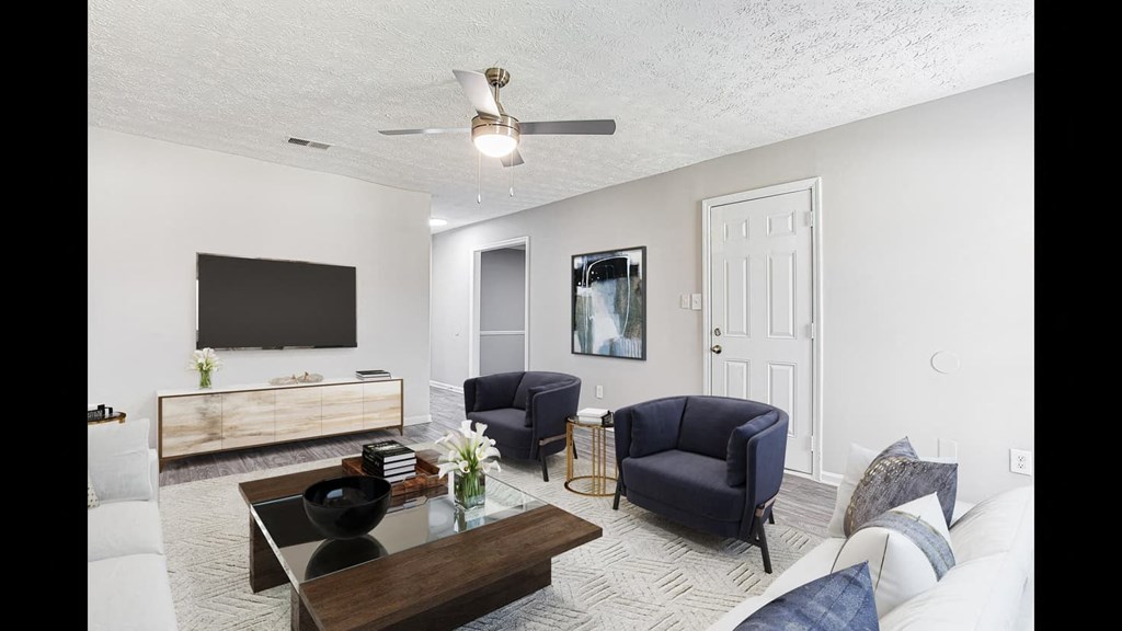 a living room with a couch and chairs and a tv
