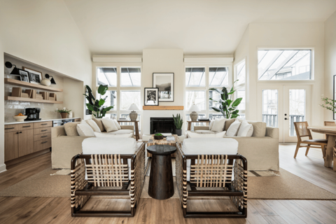 A living room with two white couches and a fireplace.