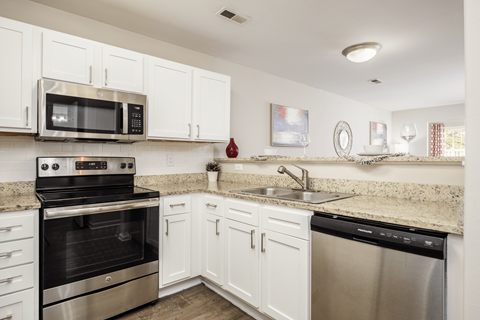 A kitchen with white cabinets and stainless steel appliances.