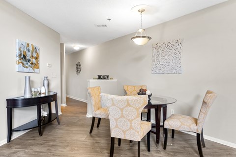 A dining room with a table and chairs.