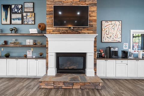 A living room with a fireplace and a flat screen TV mounted above it.