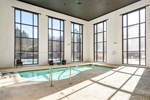 A large room with a pool and a lot of windows.