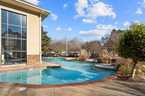 A swimming pool in front of a house.