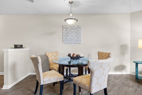 A dining room with a table and chairs.