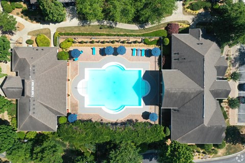 An aerial view of a house with a pool and a garden.