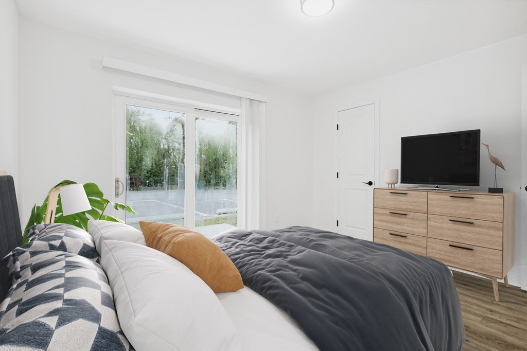 a bedroom with a bed and a tv on a dresser