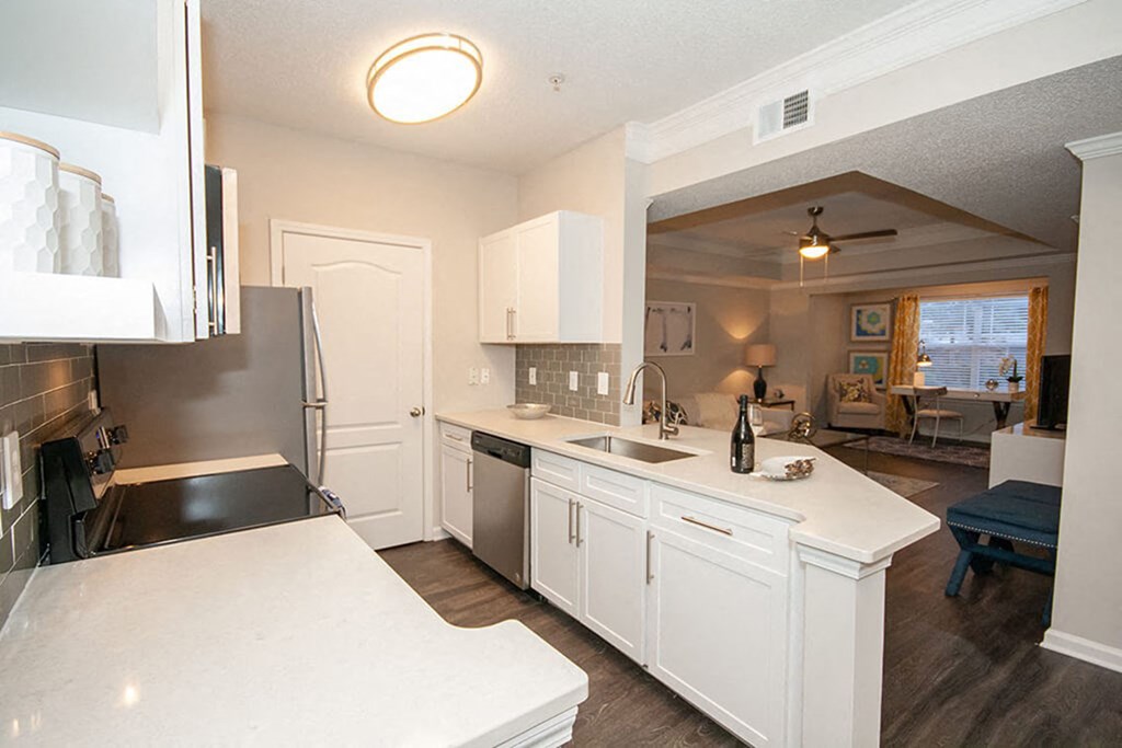 A kitchen with white cabinets and a black counter top.