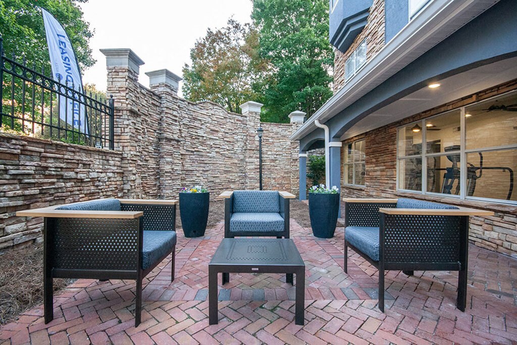 A patio with a table and chairs is set up outside a house.