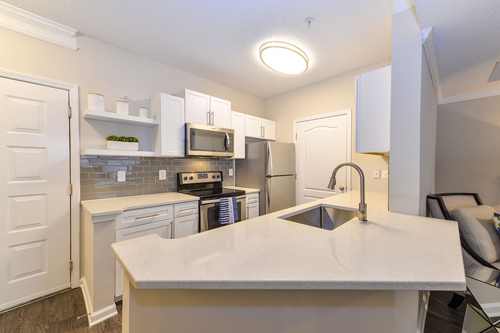 A kitchen with a white countertop and a sink.