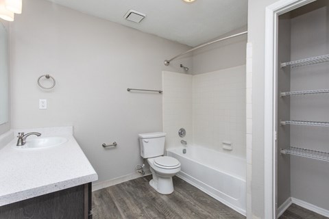 A white bathroom with a toilet, sink, and bathtub.