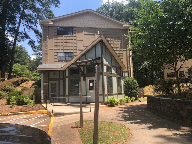 A building with a triangular design in front of a parking lot.