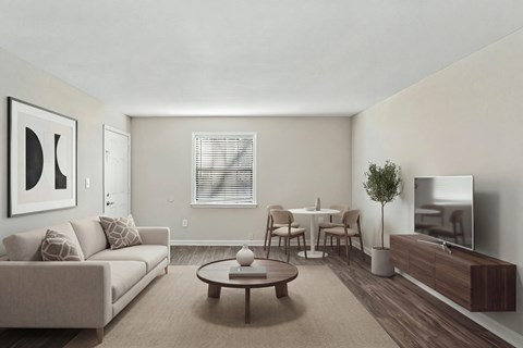 A living room with a couch, chairs, a coffee table, and a television.
