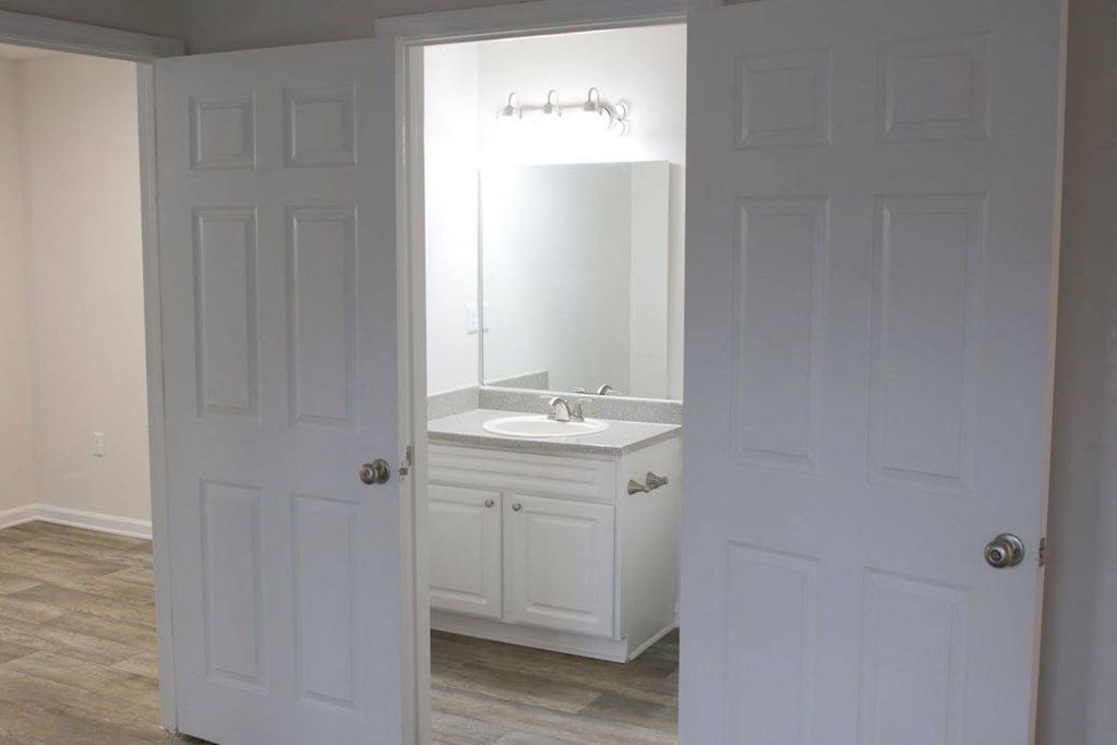 a white bathroom with a sink and a mirror