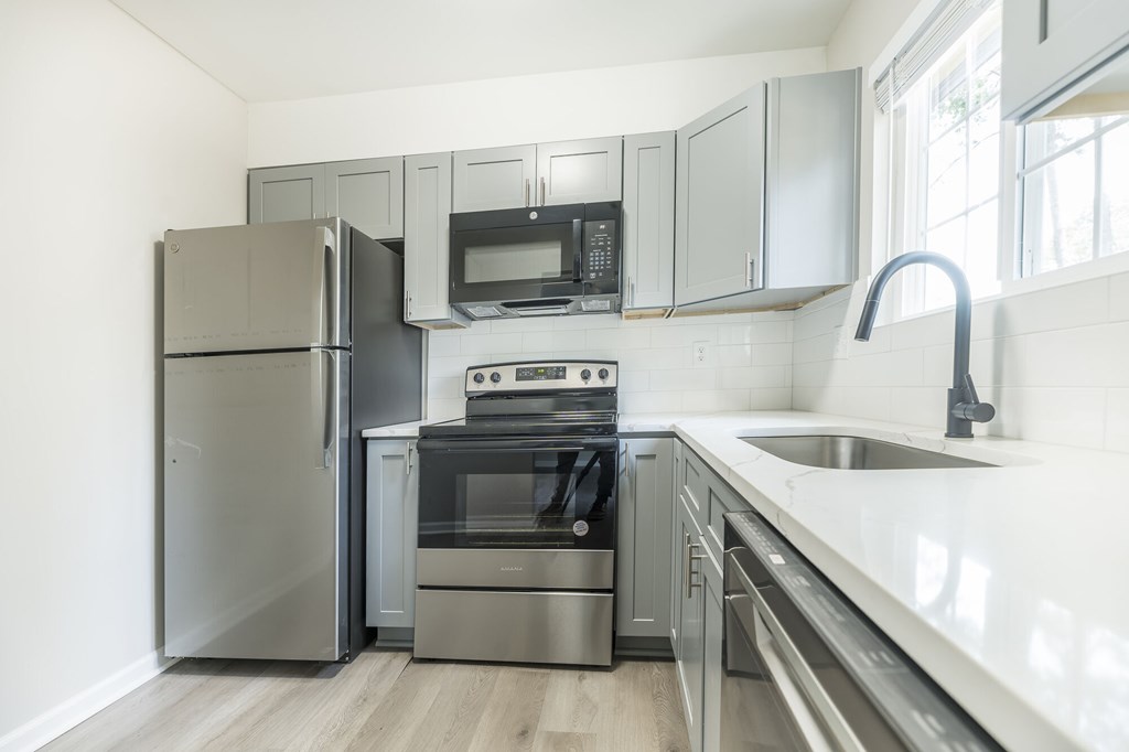 A modern kitchen with stainless steel appliances and a white countertop.