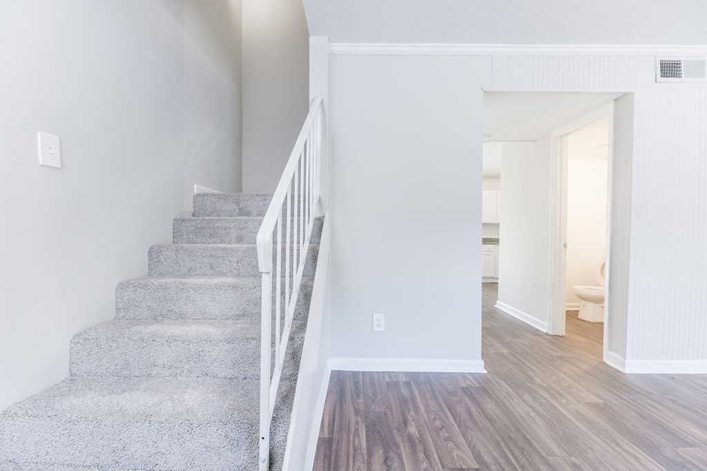 A staircase with a wooden floor and white railings.