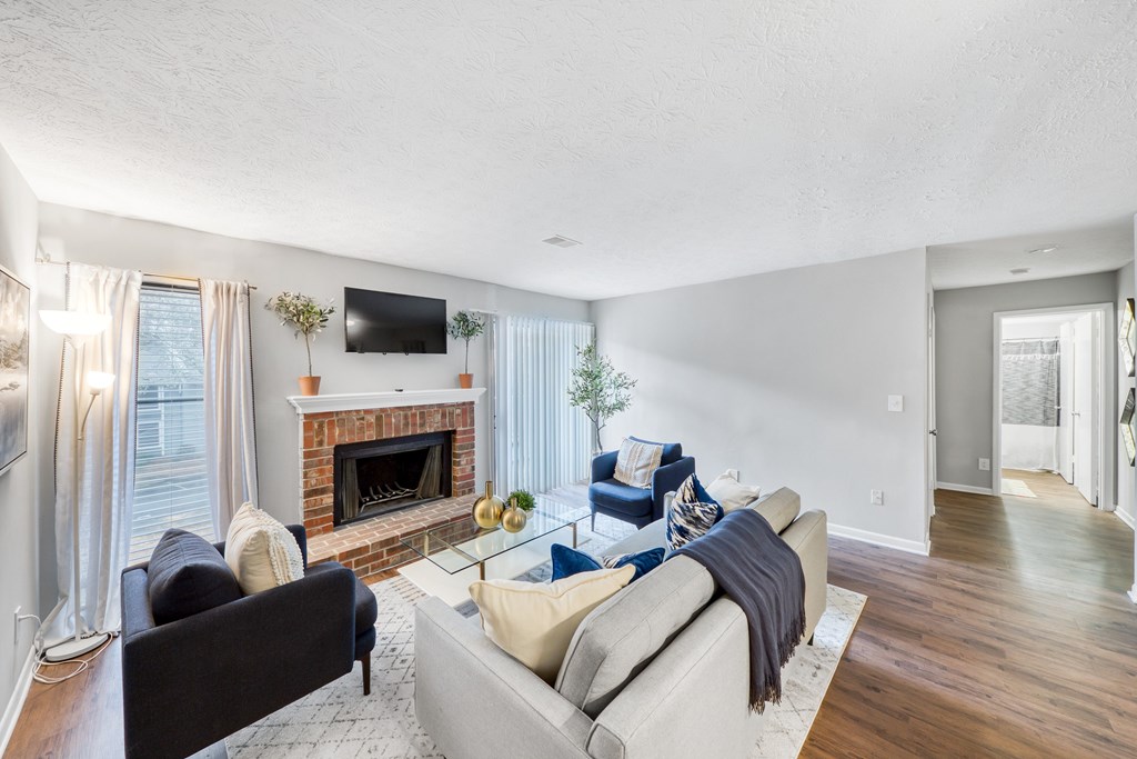 A living room with a fireplace and a television on the wall.