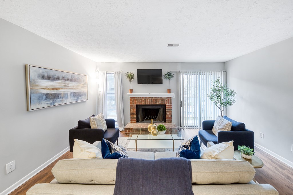 A living room with a fireplace and a painting on the wall.