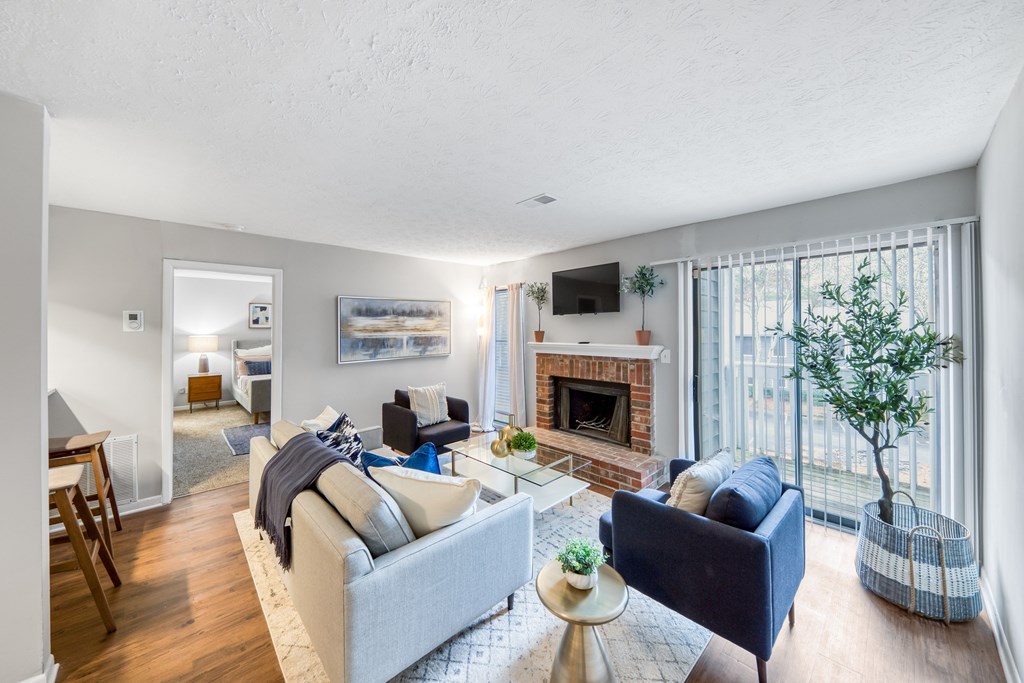 A living room with a fireplace and a blue couch.