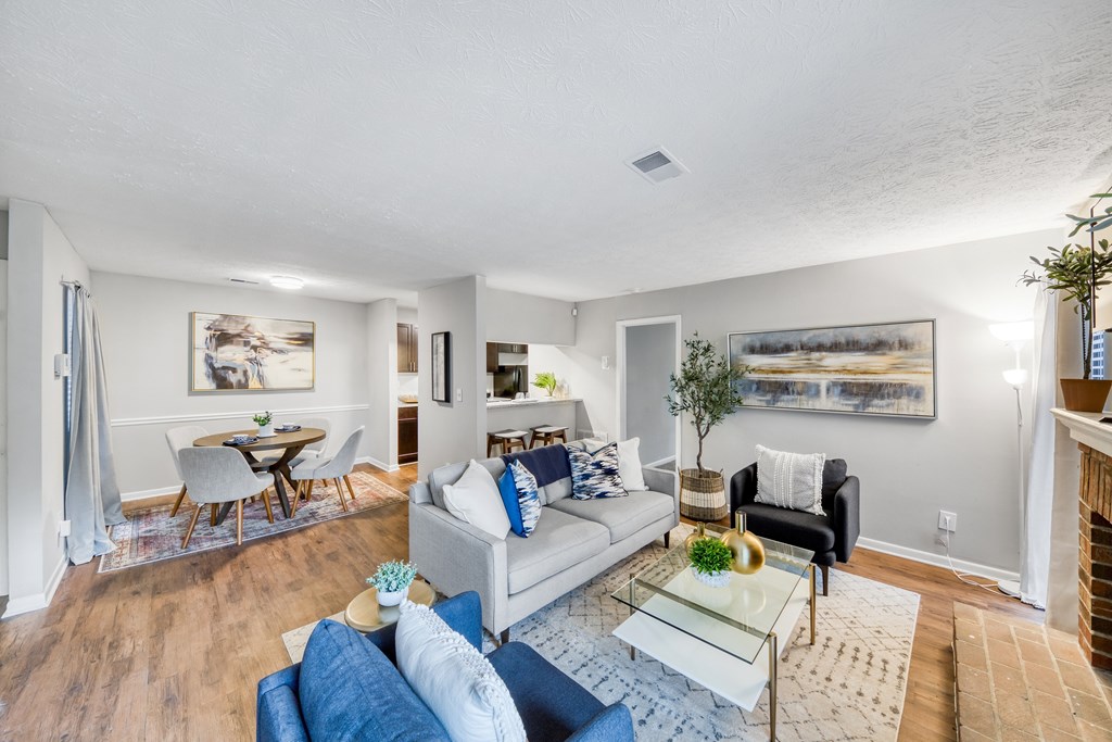 A living room with a white couch and a glass coffee table.