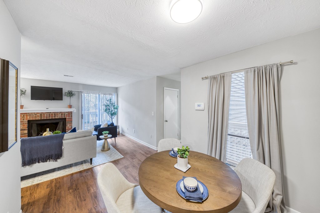 A living room with a fireplace and a dining table set for two.
