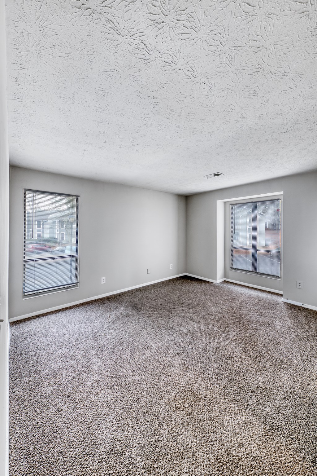 A room with a carpeted floor and a window.