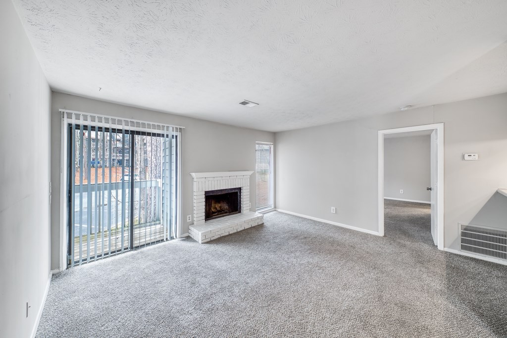 A spacious living room with a fireplace and sliding glass doors.