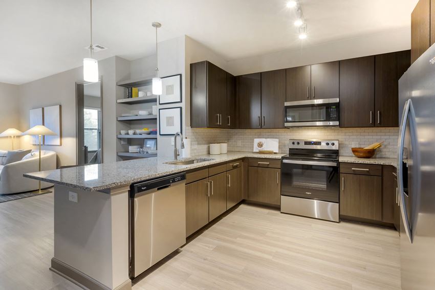 a kitchen with a large center island with a granite countertop