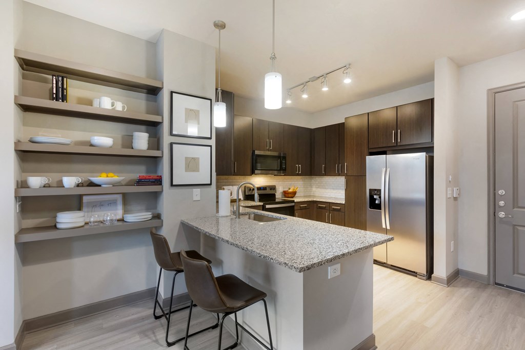 a kitchen with a large island with granite countertops