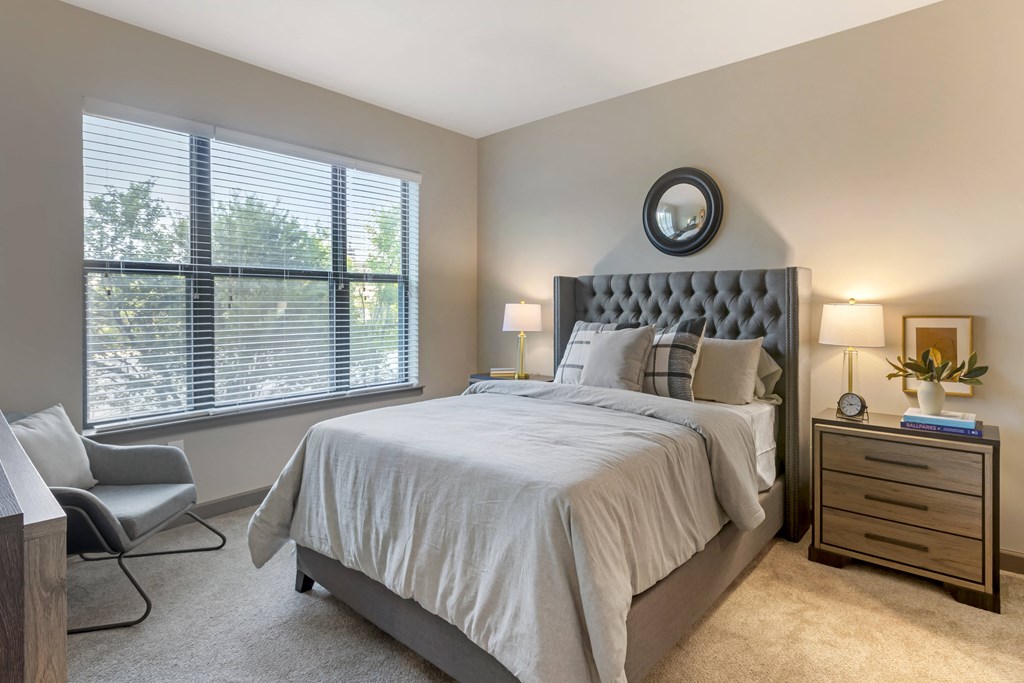 a bedroom with a bed and two windows