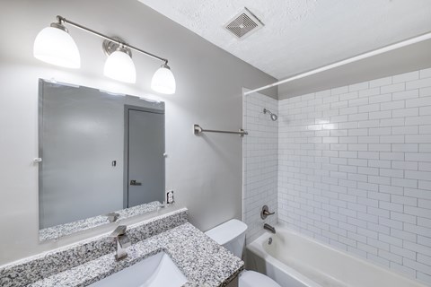 A white bathroom with a sink, toilet, and bathtub.