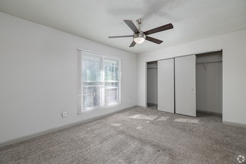 A room with a ceiling fan and a window.