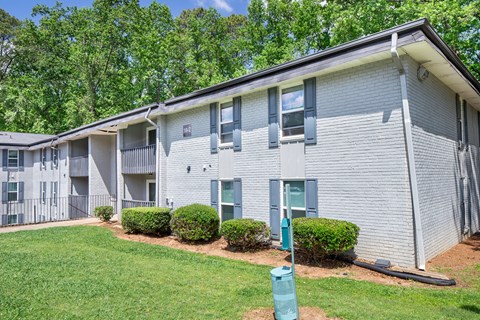 Apartment building with green bushes in front.