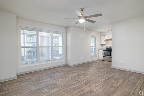 A room with a ceiling fan and wooden flooring.