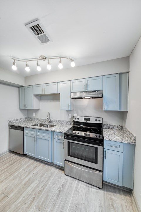 A modern kitchen with a stove top oven and a sink.