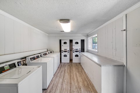 A laundry room with a washer and dryer on the left and a washing machine on the right.