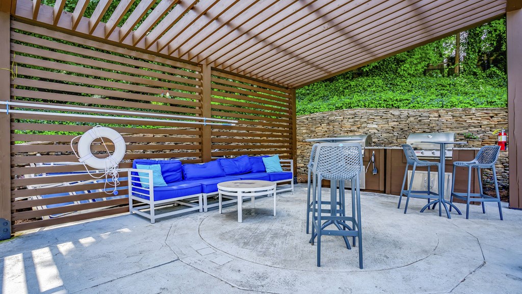 a patio with a blue couch and chairs and a bar