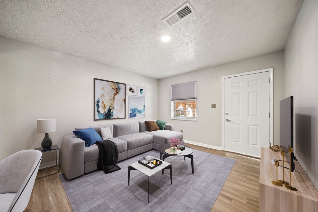 A living room with a grey couch and a grey chair.