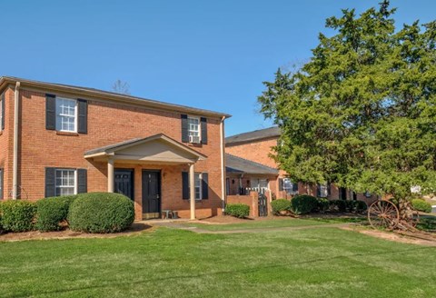 A brick house with a black door and windows.