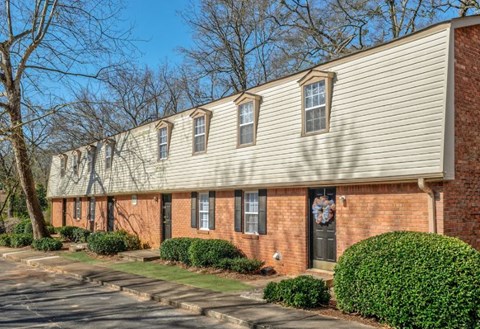 A row of houses with a black door and a wreath on the door.