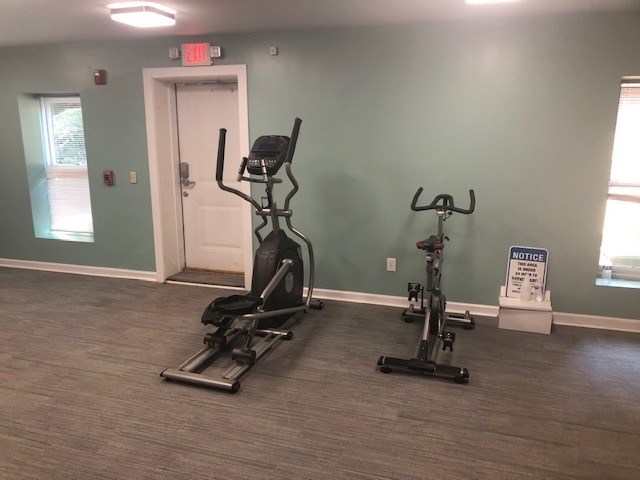 A gym with a treadmill and exercise bike.
