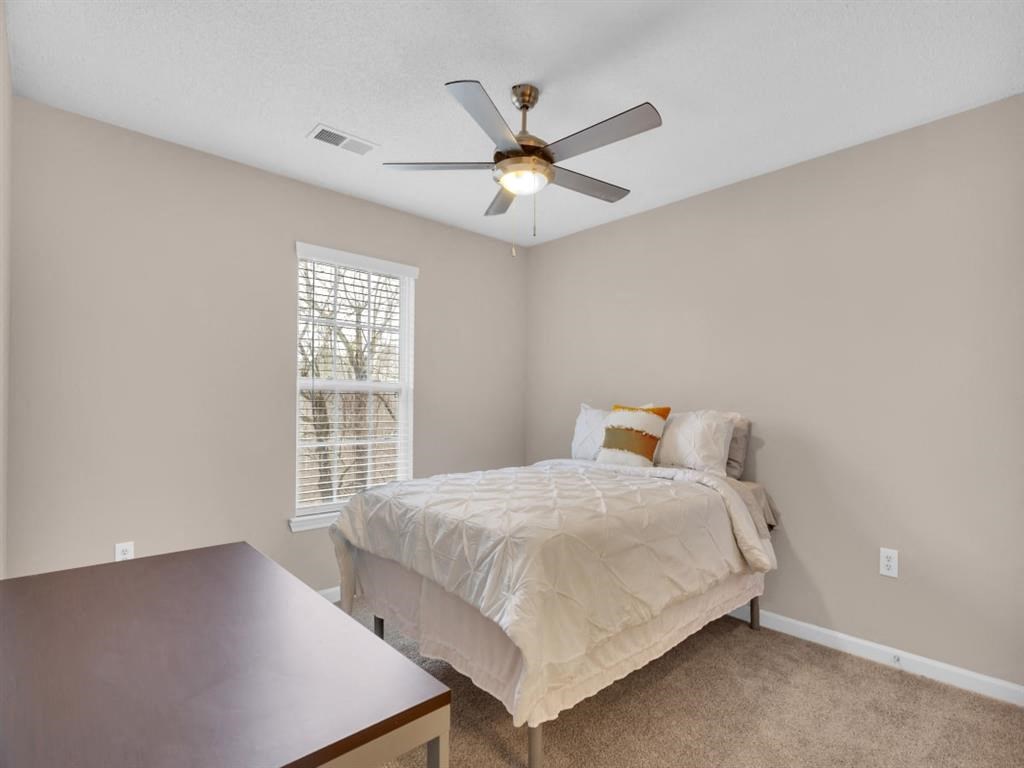 a bedroom with a bed and a ceiling fan