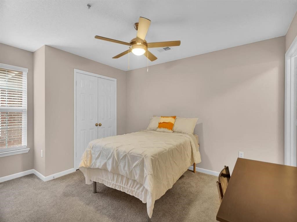 a bedroom with a bed and a ceiling fan