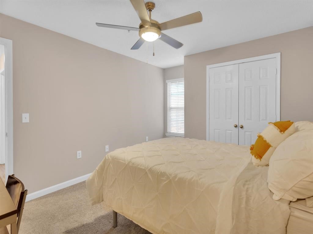 a bedroom with a bed and a ceiling fan