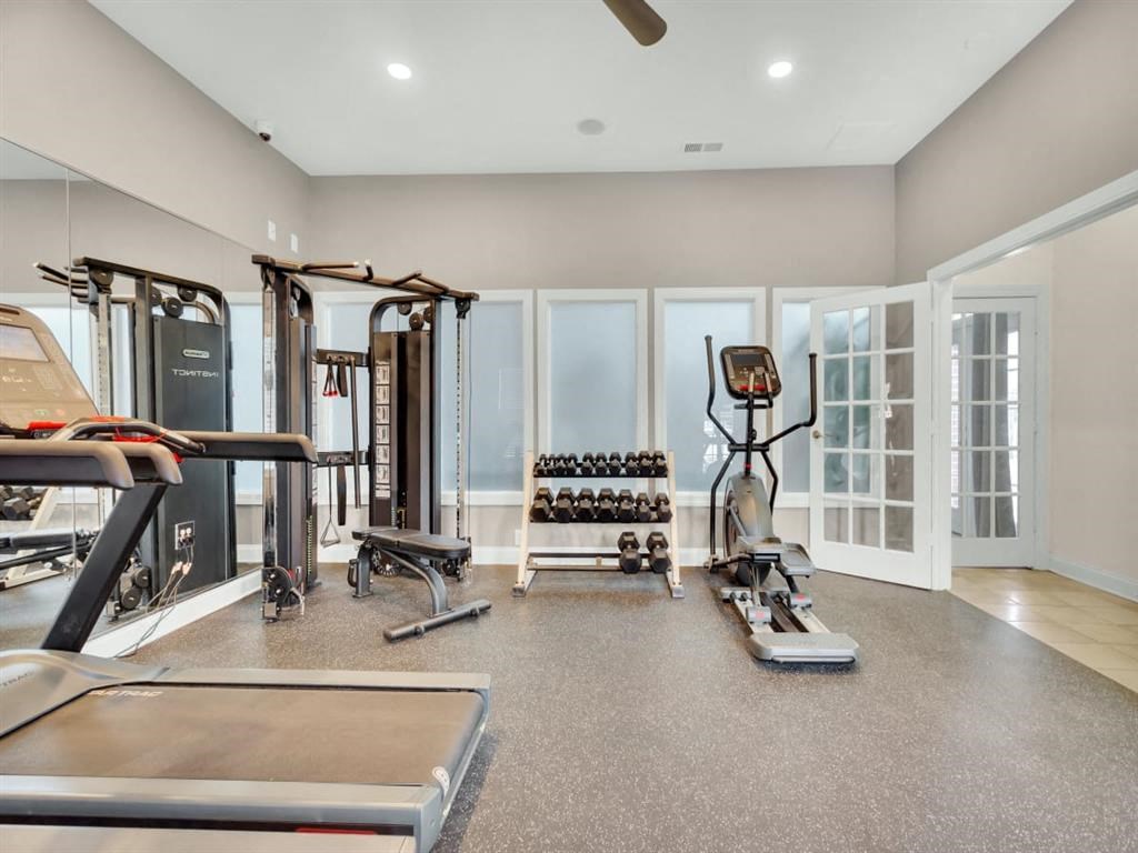 a gym with weights and cardio equipment in a new home