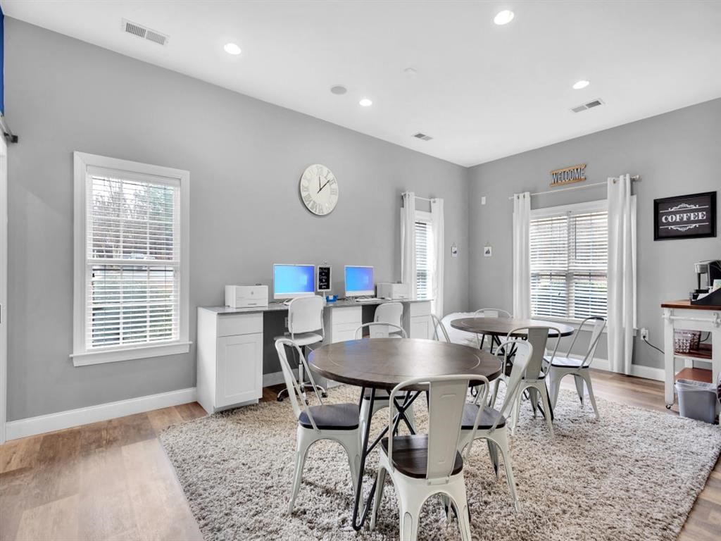 a dining room with a table and chairs and a clock on the wall
