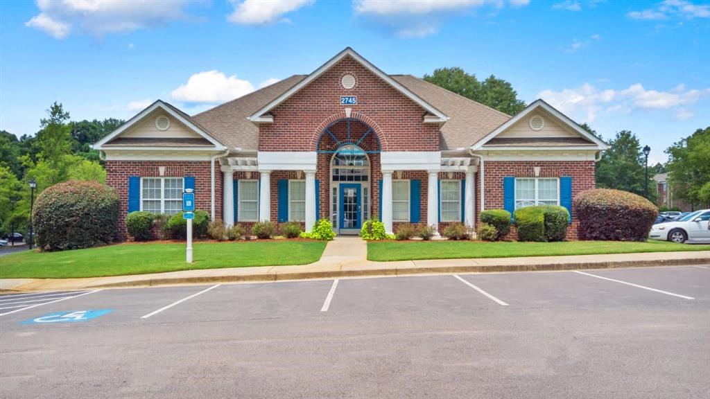 a large brick house with blue shutters and a driveway