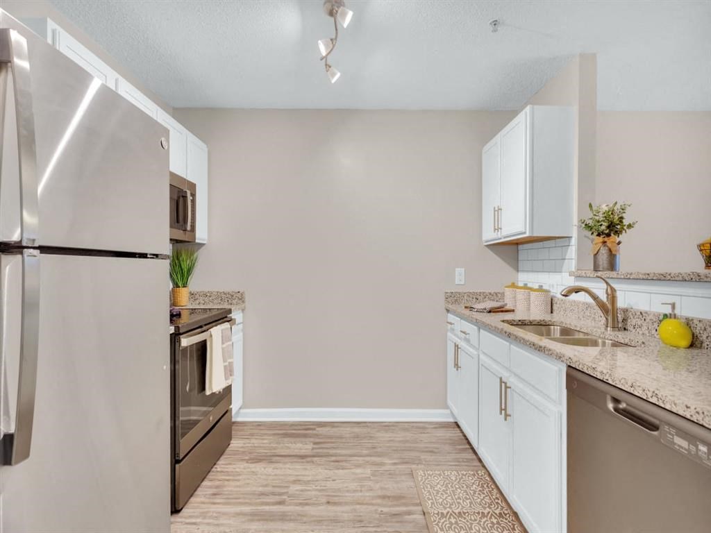 a kitchen with stainless steel appliances and white cabinets