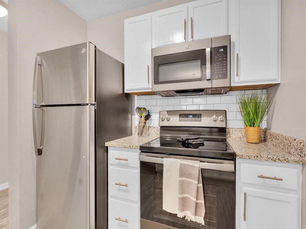 a kitchen with stainless steel appliances and white cabinets